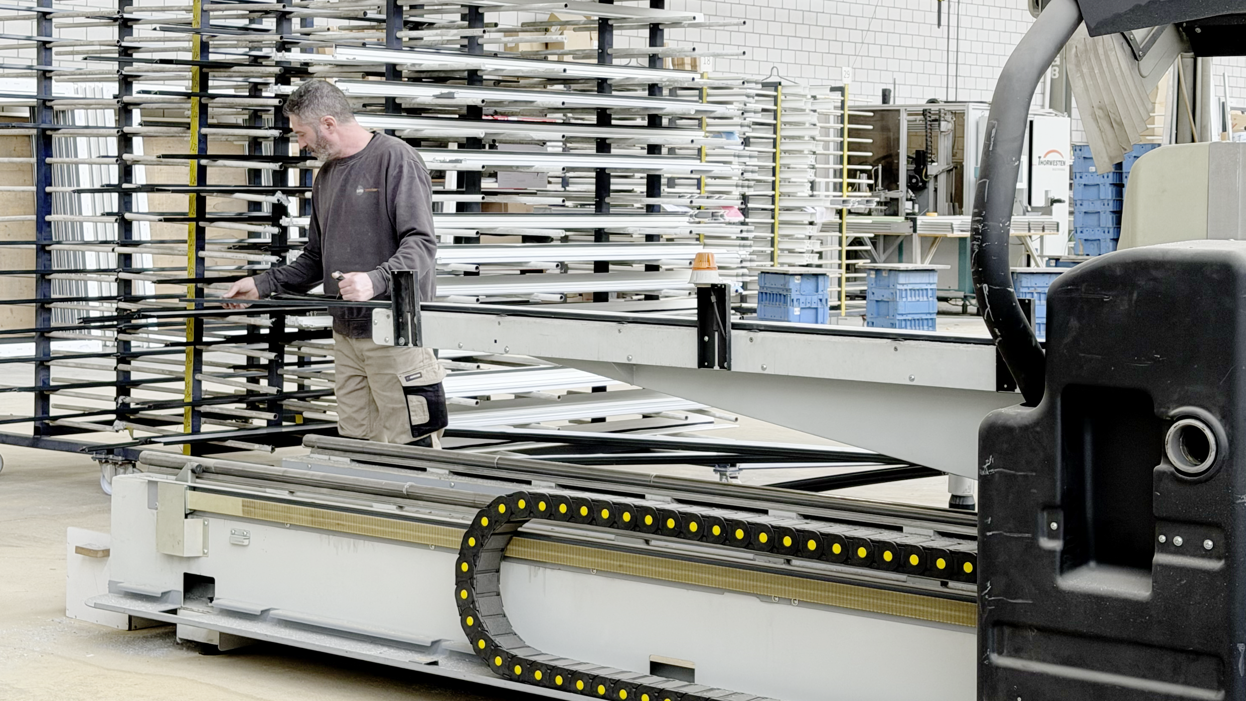 Mann steht an der Produktionsstrasse einer Fensterproduktion