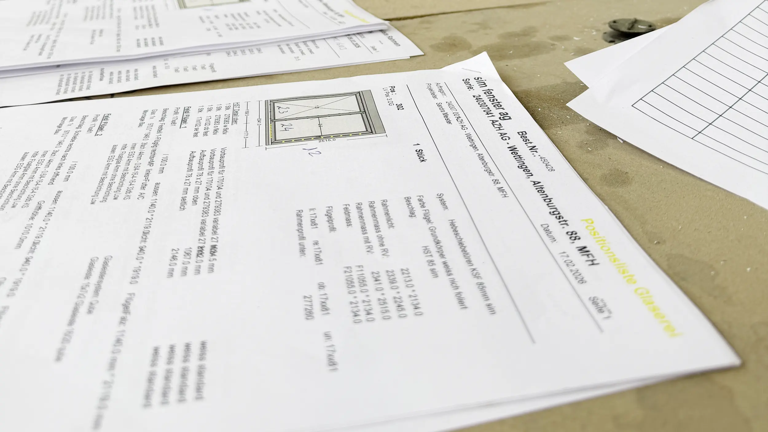 Produktionspläne und Auftragsblätter für die Fensterproduktion auf einem Tisch