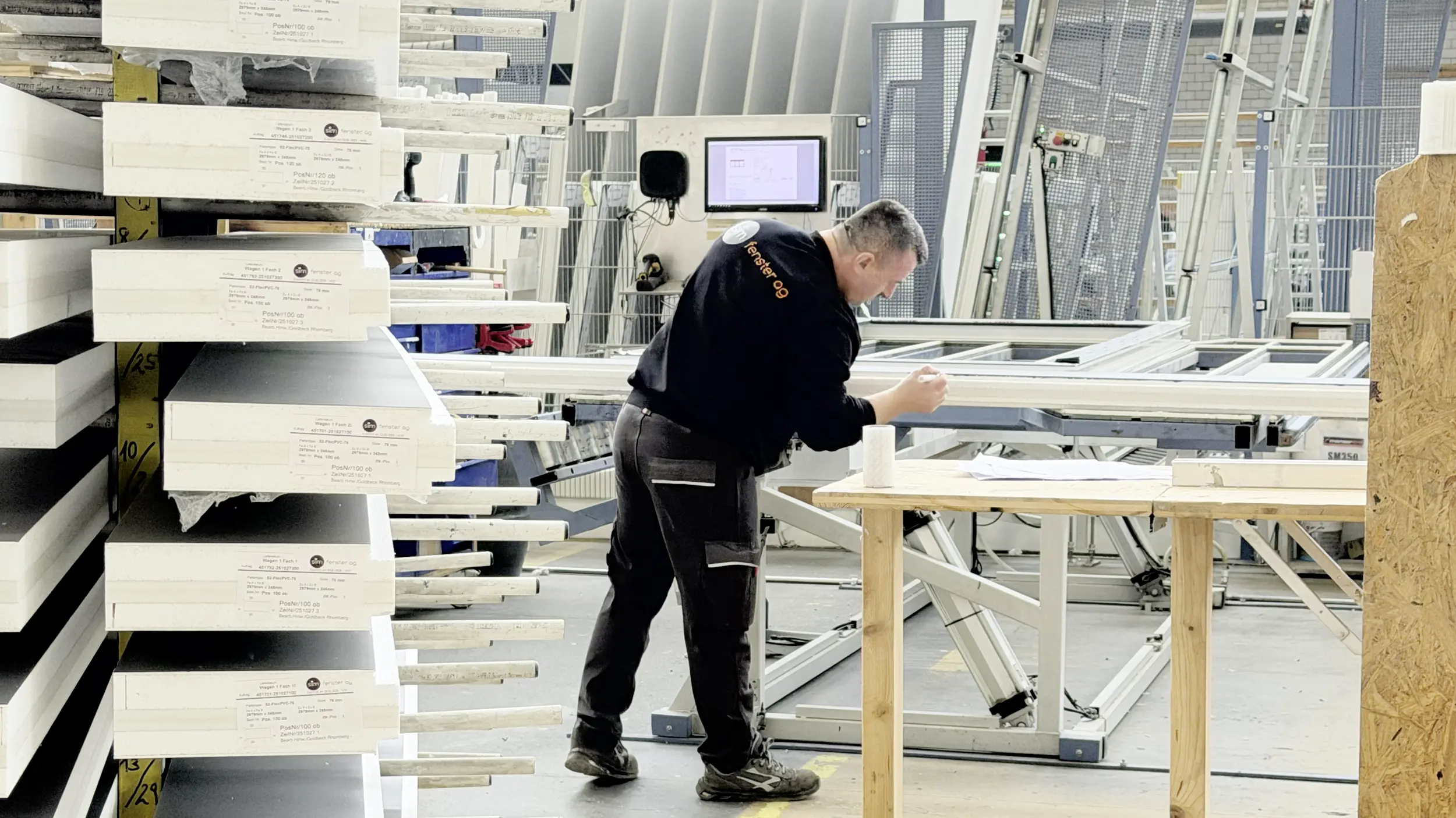 Mann beim Zuschnitt von Fnsterprofilen für die Fensterproduktion