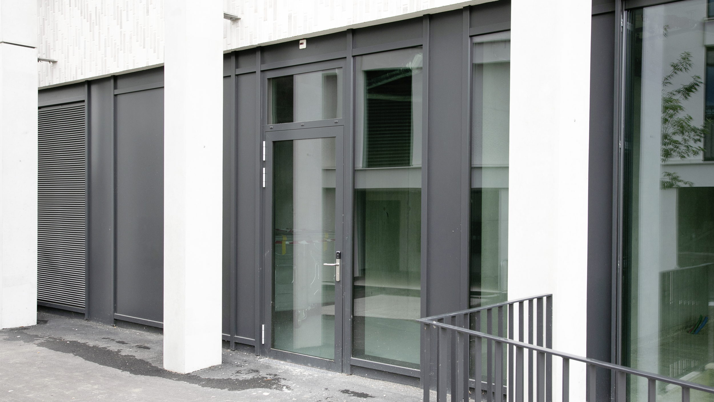 Seitenansicht einer Haustüre aus Glas einer Wohnüberbauung