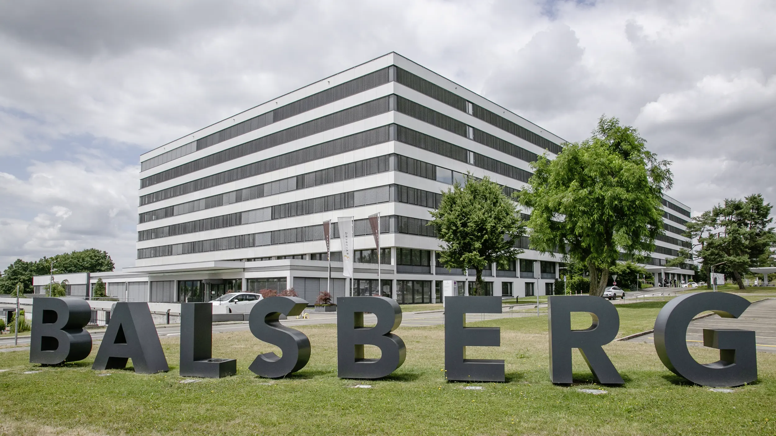 Geschäftshaus Balsberg in Dreiviertelansicht mit Schriftzug im Vordergrund