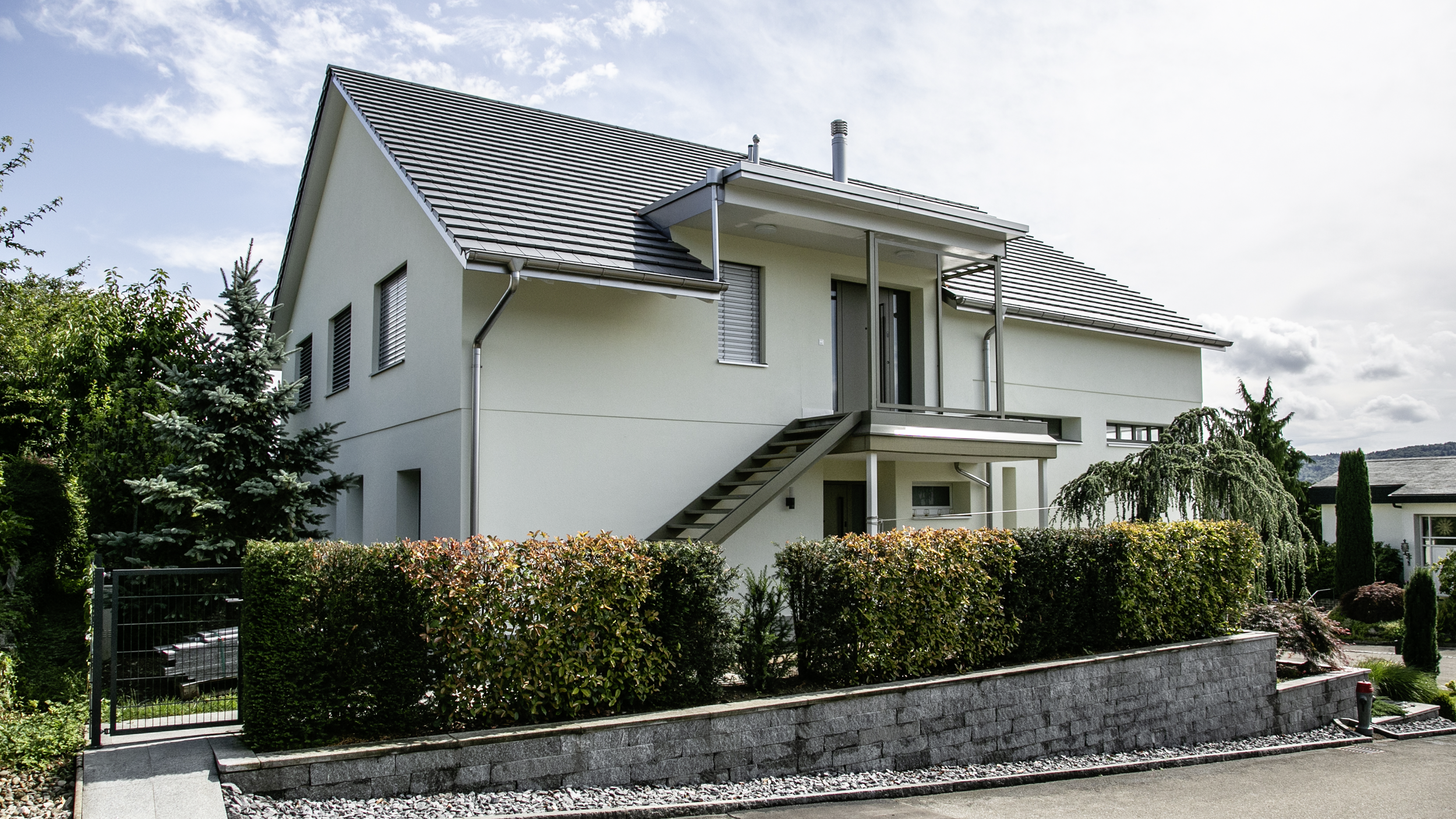 Seitenansicht eines Mehrfamilienhauses nach Sanierung und Aufstockung